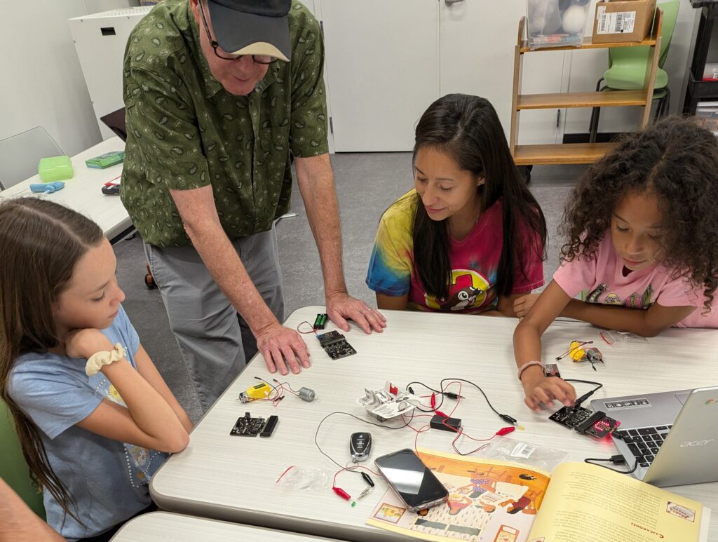 A group of children learn about robotics during a STEM event with Families Learning Together at San Marcos Public Library