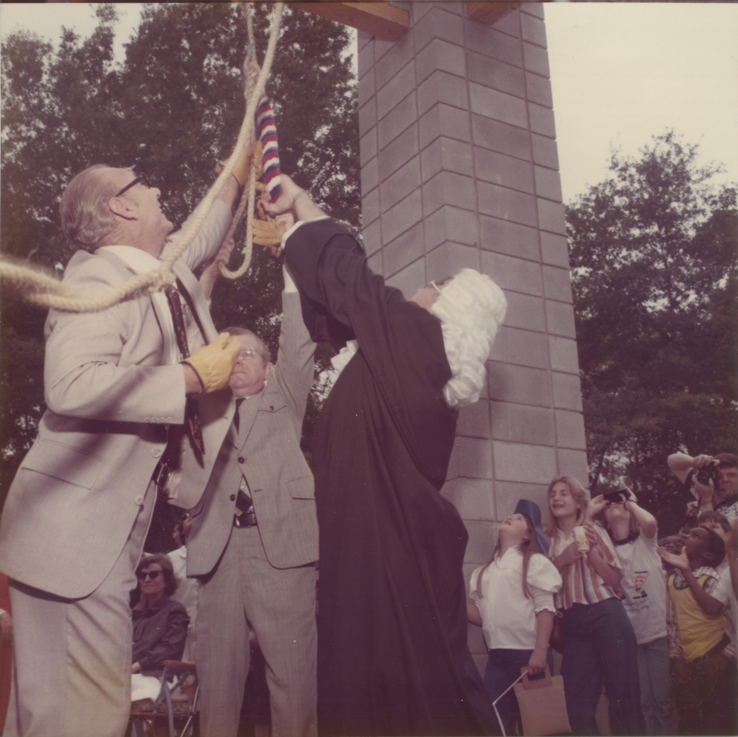 Three men actively pulling the rope to ring the bell during the bicentennial festivities. Liberty Mayor Paul Daniels, Charles W. Fisher Jr., and Liberty County Judge Harlan Friend ring Liberty’s Liberty Bell at the bell tower dedication ceremony, April 24, 1976.
